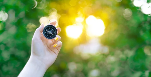 Mano Con Brújula Sobre Fondo Verde Borroso Con Resplandor Solar —  Fotos de Stock