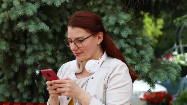 Mulher atraente, bem sucedida e feliz usando telefone celular para mensagens de texto ou mídia social — Vídeo de Stock