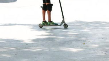 Şehrin peyzajındaki sporcu bir numara yapıyor. Beton bir kaseden atlayan kaykaycı.