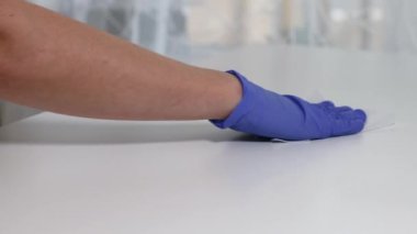 Corona virüsü COVID-19 'un yayılmasına karşı merkez ofisteki masa yüzeyini silmek için ıslak mendilleri dezenfekte etmek.