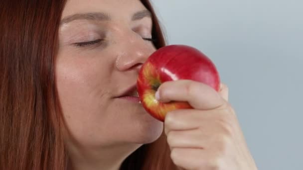 Radosna młoda dama jedząca dojrzałe czerwone jabłko, ciesząca się świeżą organiczną przekąską, zdrowym jedzeniem i stylem życia — Wideo stockowe