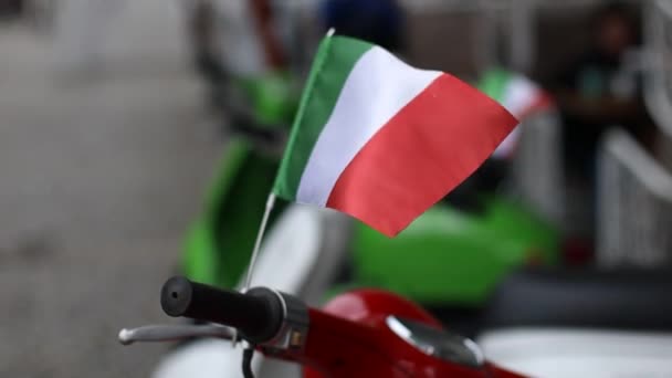 Італійський прапор на мотоциклі розмахує вітром у міському саду, закриваючи двері — стокове відео