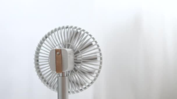 Elegante ventilador de enfriamiento eléctrico blanco funciona en un día de verano en una habitación en casa. Tiempo caluroso de verano. Vista trasera — Vídeos de Stock