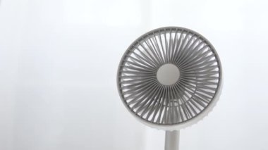 Açık beyaz arkaplanda beyaz masaüstü elektrikli vantilatör.