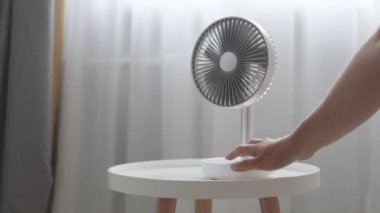 Beyaz masaüstü elektrikli vantilatör açık tahta masada. Pervaneyi açıyorum.