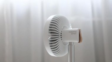 Güneşli bir yaz gününde oturma odasında beyaz metal vantilatörle pervaneyi kapat. Soğutma sıcaklığı.