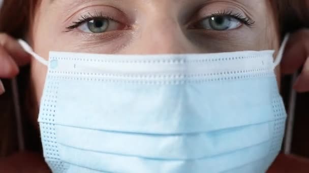 Närbild kvinna ansikte bär medicinsk mask för att förhindra damm och infektion virus. — Stockvideo