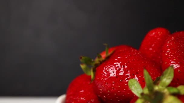 Čerstvé organické červené zralé jahodové ovoce na tmavém pozadí, zblízka — Stock video