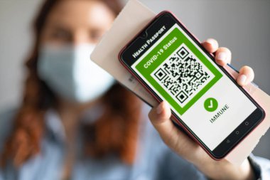 Dijital sağlık pasaport uygulamalı akıllı telefon ekranı. Aşılanmış kişi covid-19 salgını sırasında seyahat için cep telefonundaki sağlık pasaport uygulamasını kullanıyor..