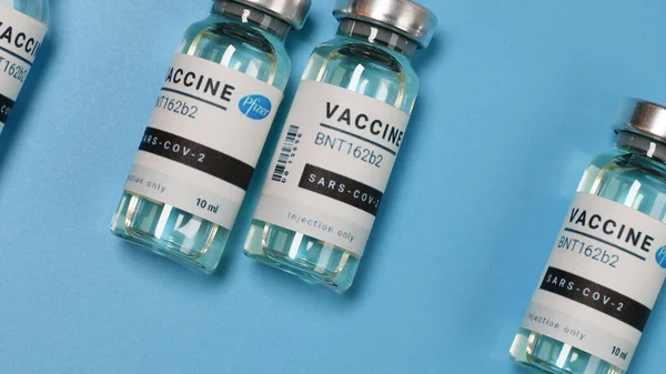 Frascos experimentais de vacina contra o Coronavirus covid-19 numa placa azul com copyspace em laboratório. Vacinação e imunização — Fotografia de Stock