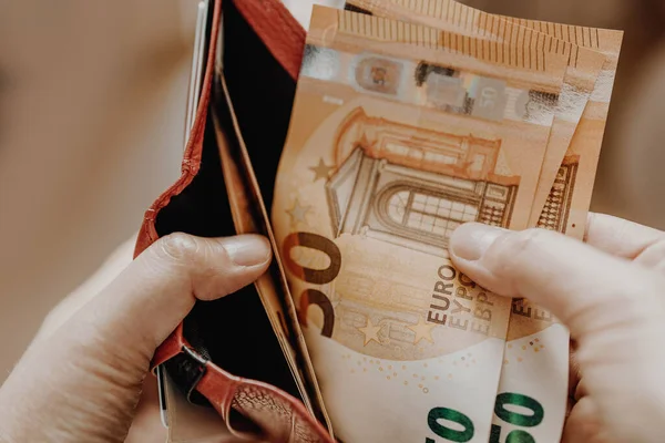 Человек, вытаскивающий деньги евро из кармана — стоковое фото