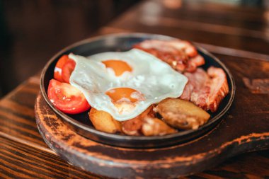 Lokantada yumurta, pastırma, domates ve sosis ile iştah açıcı bir kahvaltı.