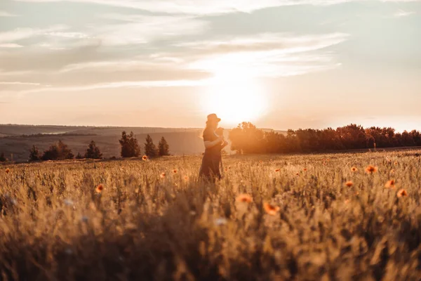 Молодая женщина отдыхает на поле под солнечным светом — стоковое фото