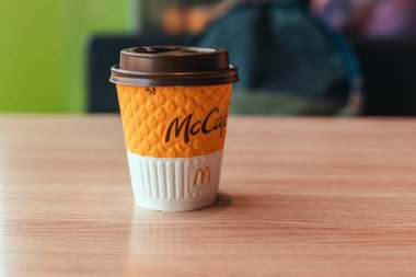 Odessa, Ukrayna - Mart 05 2021: Bir kafedeki ahşap masada kağıt bardak McDonalds kahvesi