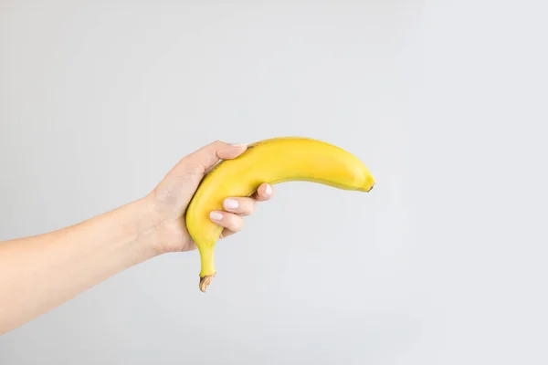 Жіноча Рука Тримає Жовтий Банан Яскравому Сірому Тлі Здорова Закуска — стокове фото
