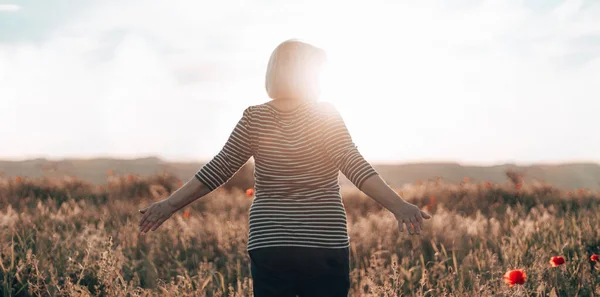 Mujer senderista de pie en el campo y mirando el horizonte con hermoso cielo al atardecer. Hermoso paisaje, libertad, la unidad del hombre y la naturaleza —  Fotos de Stock