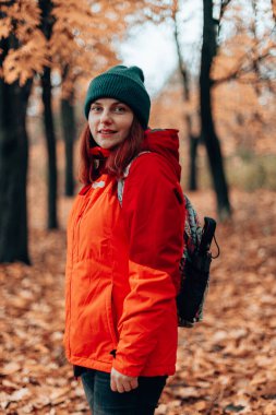 Geçmişe bakış çekici beyaz kadın sonbahar ormanlarında sırt çantasında yürüyüş yapıyor, aşırı yaşam tarzı, özgürlük kavramı..