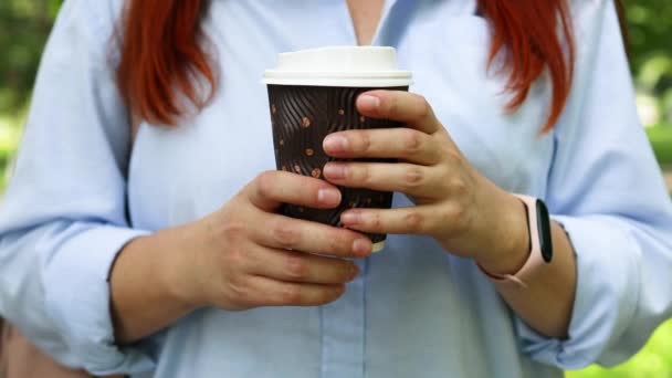 Kobieta trzyma papierową filiżankę gorącej kawy lub herbaty na zewnątrz w pochmurny dzień — Wideo stockowe