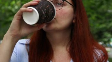 Güzel iş kadını kahve içiyor ve parkta işten dinleniyor. Kentsel yaşam tarzı kavramı