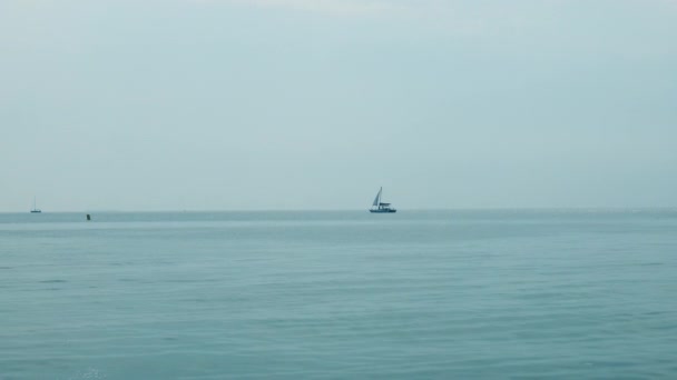 Denizin sessiz dalgalarında yüzen bir tekne. Seyahat konsepti ve fikri. Mavi deniz ya da okyanus su yüzeyi ve su altı — Stok video