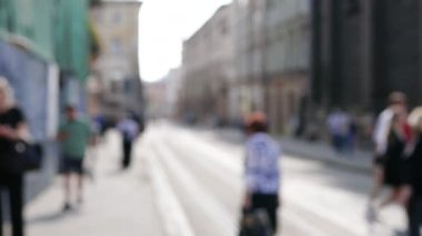 Şehir caddesinde yürüyen tanınmayan isimsiz kişilerin odak dışı videosu.