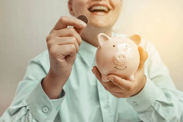 Счастливая женщина сэкономить деньги на копилку со счастливым лицом, сэкономить деньги концепции — стоковое фото