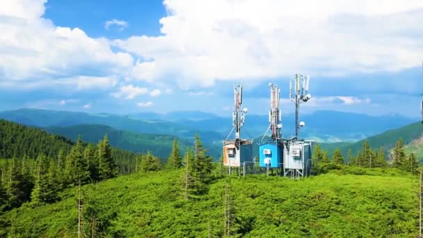 Antena torre de telecomunicaciones en brillantes colinas de pinos siempreverdes de montaña. Montañas Cárpatos en Ucrania. — Vídeo de stock