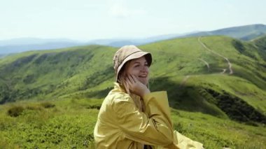 Çekici, neşeli kadın, doğanın güzelliği ve gücünün tadını çıkarıyor. Güzel dağların manzarası.