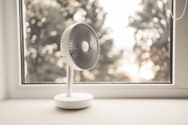 Evdeki yatak odasındaki modern elektrikli vantilatör. Yüksek hava sıcaklığı serinliyor. Asgari biçim, kopyalama alanı.
