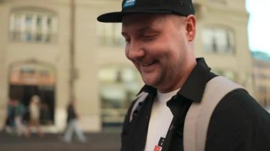 Güneşli bir günde Roma sokaklarında yürüyen gülümseyen bir gezgin. Sahne, olumlu duygular, rahatlama ve İtalya 'da yeni hedefler keşfetmenin sevincini taşıyor..