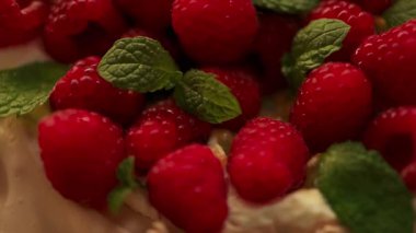 Olgun ahududu ve nane yapraklarıyla süslenmiş, Macro şekerli tatlı. Taze ve lezzetli pavlova tarzı pasta. Ev yapımı tatlı, gurme yemekleri ve zarif pasta sunumu kavramı..