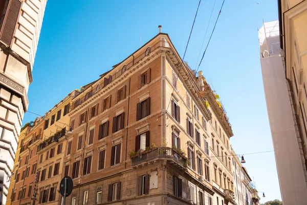 Roma, İtalya - 3 Ekim 2025: Roma şehir merkezinde güneşli bir günde tarihi konut binaları yakınlarındaki bir caddeden geçen yayalar.