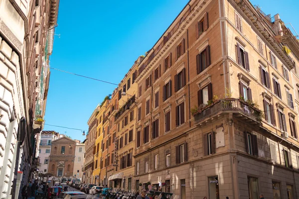 Roma, İtalya - 3 Ekim 2025: Roma şehir merkezinde güneşli bir günde tarihi konut binaları yakınlarındaki bir caddeden geçen yayalar.