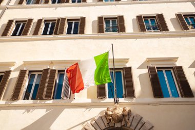 Roma, İtalya - 4 Ekim 2025: Roma şehir merkezinde tarihi bir binanın cephesinde asılı İtalyan ulusal bayrakları.