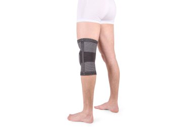 Diz Destek Kolu beyaz arka planda izole edilmiş bir bacak üzerinde. Ortopedik Anatomik Ortopedi. Diz sabitleme, yaralanma ve ağrı için diş telleri. Ortopedi. Ayak ortozu. Diz eklemi bandaj kolu. Elastik Spor