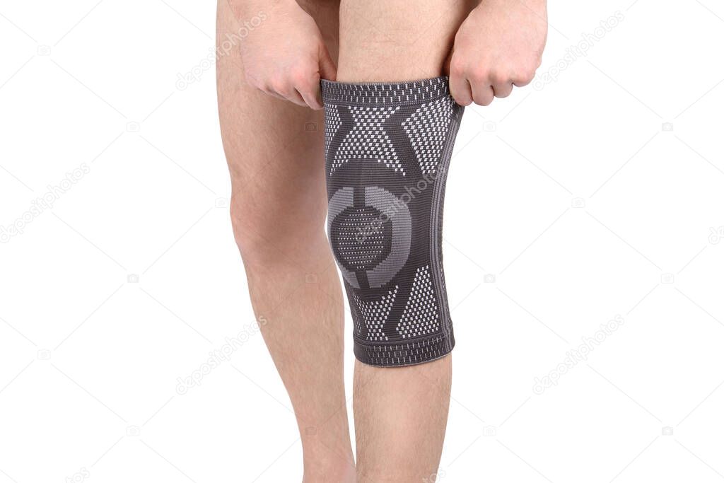 Knee Support Brace on leg isolated on white background. Orthopedic Anatomic Orthosis. Braces for knee fixation, injuries and pain. Orthotics. Foot orthosis. Knee Joint Bandage Sleeve. Elastic Sports