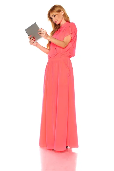 Dziewczyna w różowej sukience z komputera typu tablet — Zdjęcie stockowe