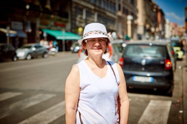 Stylish woman in hat to go in a street
