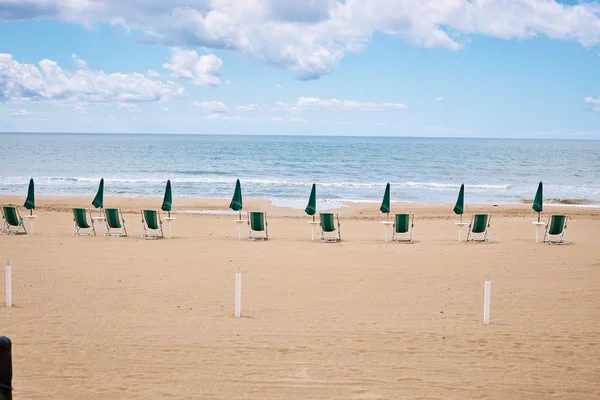 Het strand met parasols en ligbedden op kust — Stockfoto