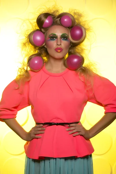 Girl with bright makeup and hair balls on a yellow background — Stock Photo, Image