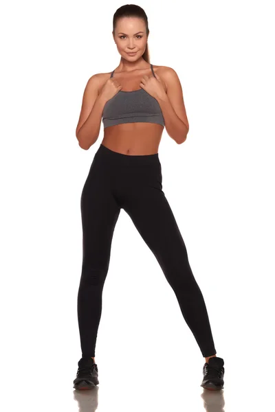 Mulher fitness em estilo esporte em pé contra fundo branco isolado — Fotografia de Stock