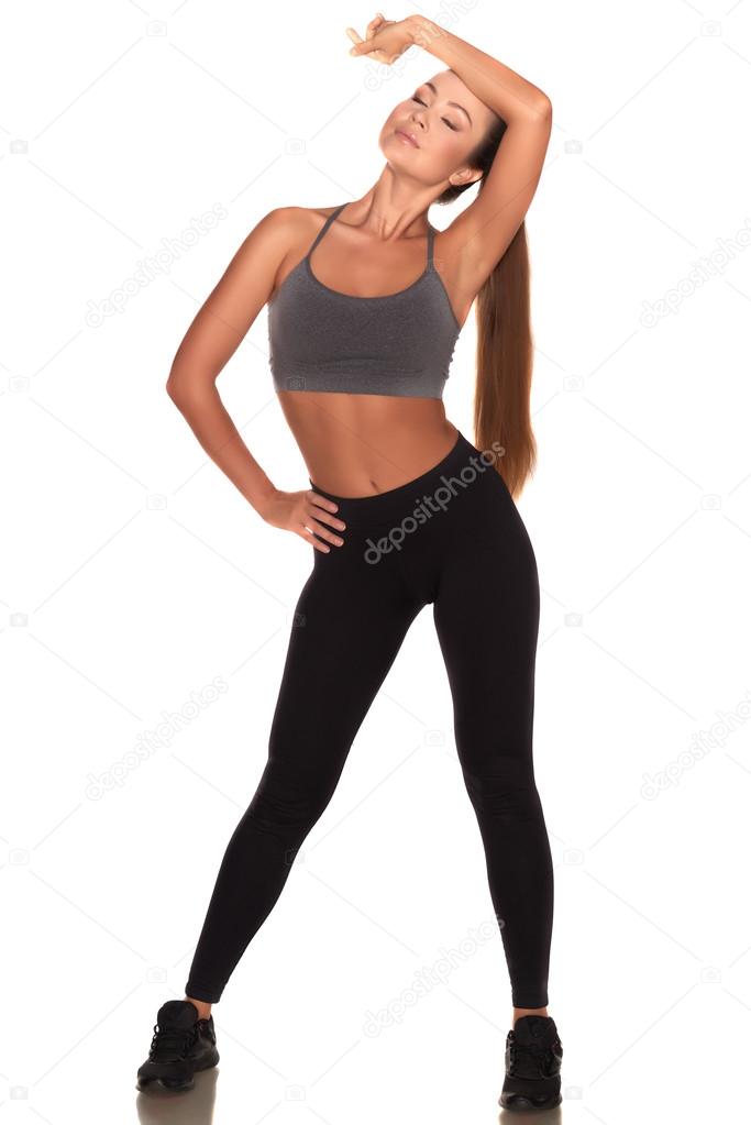 Fitness woman in sport style standing against isolated white background