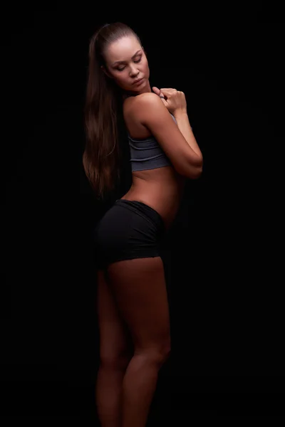 Karanlık bir arka plan üzerinde genç kız fitness devreye girer — Stok fotoğraf