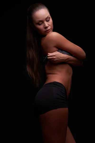 年轻的女孩，在一个黑暗的背景被从事健身 — 图库照片