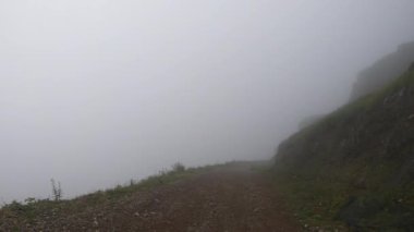 Sis içinde dağlarda yürüyüş, sübjektif görüş, bulutlu havada yürüyüş, gündüz.