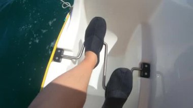 Erkek ayağı bir katamaran pedal çeviriyor. Eğlence için deniz ulaşımı, tatil köyü eğlencesi