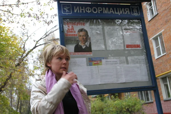 Opoziční kandidát na starostu Khimki Marek Chirikova poblíž informační stánek s kampaň v den voleb kandidáta Kreml Oleg Shakhov — Stock fotografie