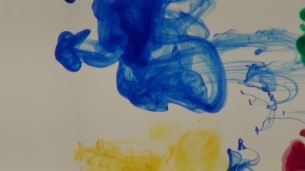 Tinta azul, verde, amarilla y roja en agua — Vídeos de Stock