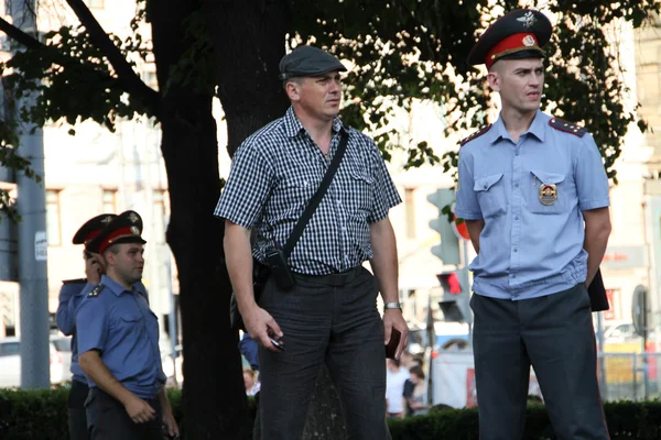 Politieagenten in een formulier en in burgerlijke kleren over de bijeenkomst van de oppositionele — Stockfoto