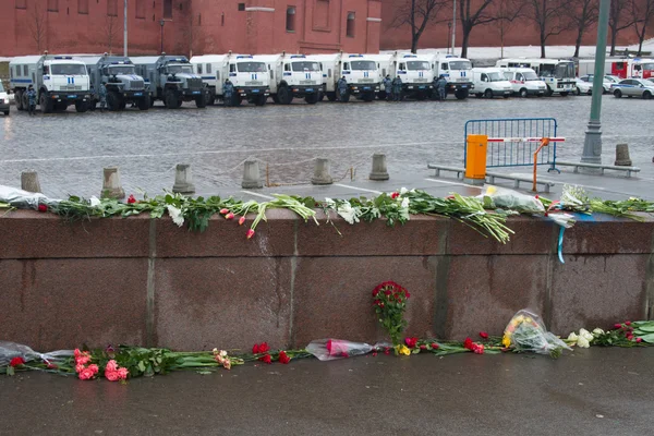 The flowers near a place of murder of the politician Boris Nemtsov and the car of police protecting the Kremlin from march of opposition — Stock Photo, Image